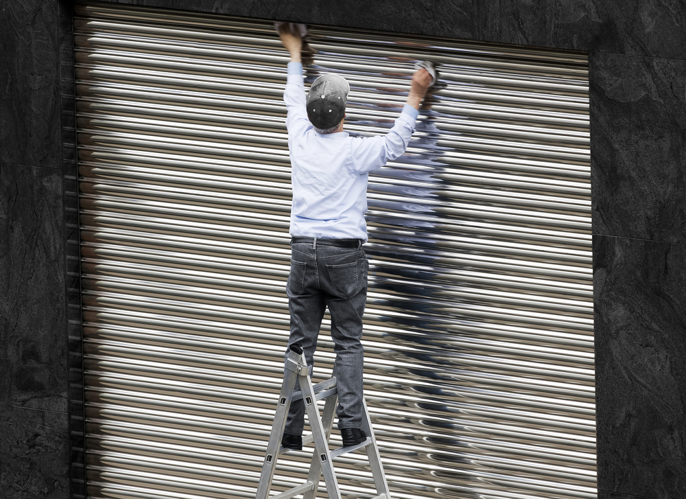 Old,Man,Working,Cleaning,Metal,Shutter,Door,Without,Safety,Equipment